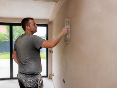 Plasterer smoothing wall surface inside modern Cardiff home