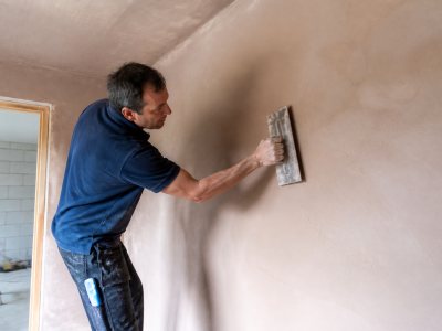 Experienced plasterer smoothing walls indoors