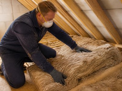 Professional installer fitting loft insulation indoors